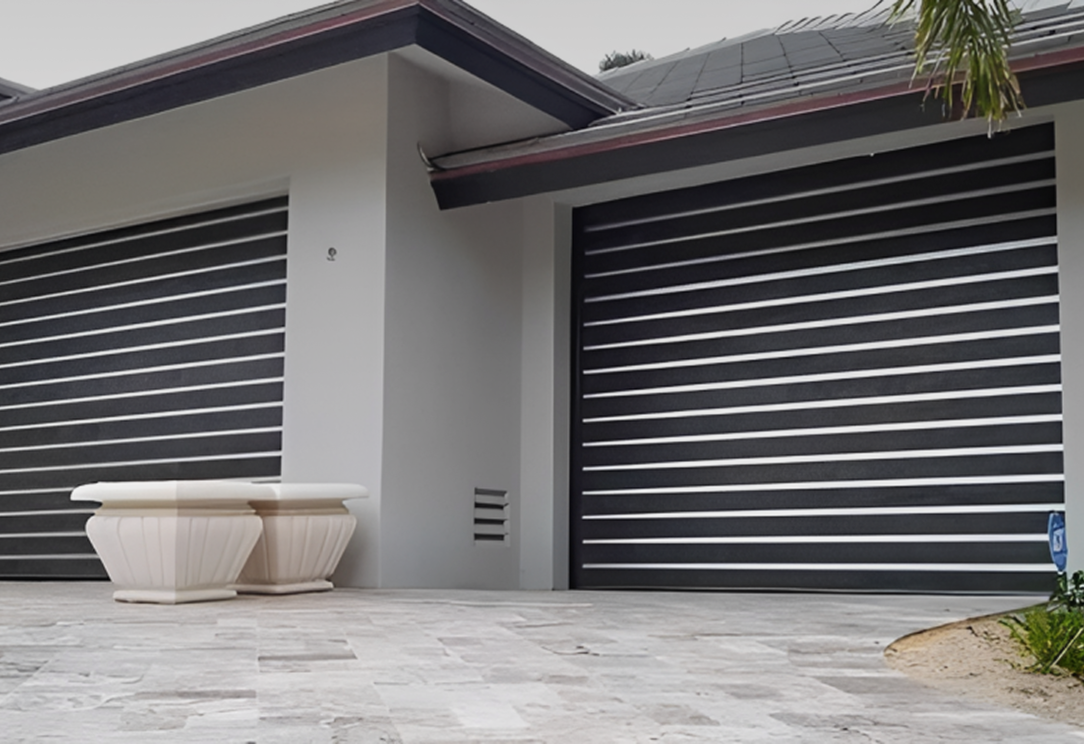 Modern house with two black garage doors.